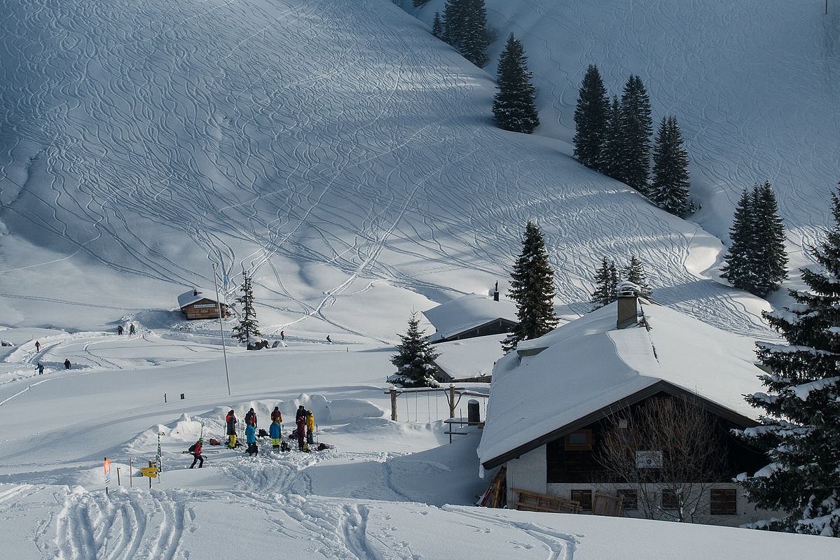 Schönfeldhütte mit den komplett zerfahrenen Hängen von Rauhkopf und Tanzeck im Hintergrund.