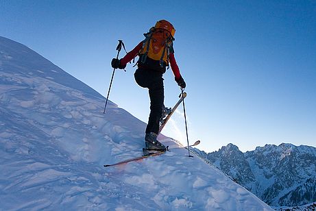 Basis ist eine stabile Ausgangsposition. Beide Ski stehen parallel in der Aufstiegsspur, solide auf dem Schnee aufliegend (bei unebenem Untergrund fest aufstampfen) und möglichst flach zur Falllinie.